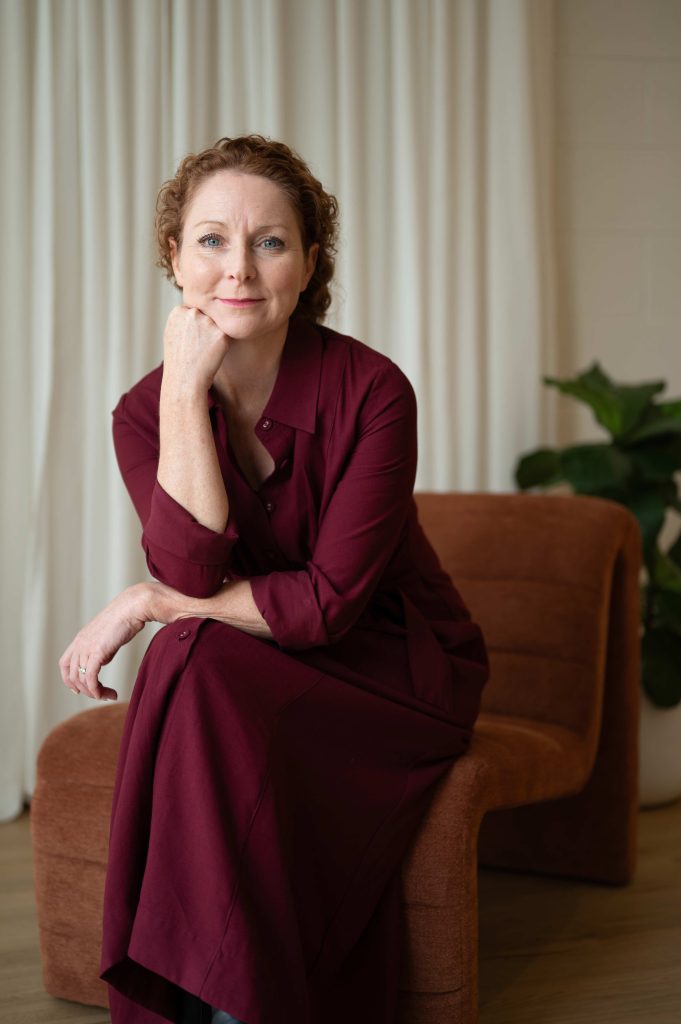 Woman in a burgundy dress seated in a chair during a personal brand photography session in the Adelaide Hills