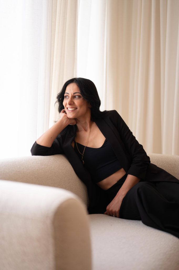 Woman in black reclining on a sofa during a professional brand headshot session