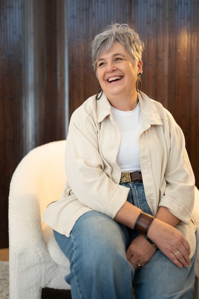 Woman laughing in a cream jacket during a relaxed brand content session in an Adelaide studio