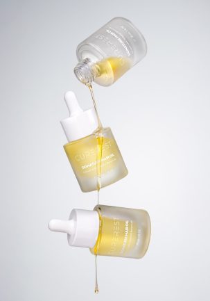 Curerest Hair Oil product shot with oil texture and droplets, campaign-ready imagery designed for ecommerce and advertising.