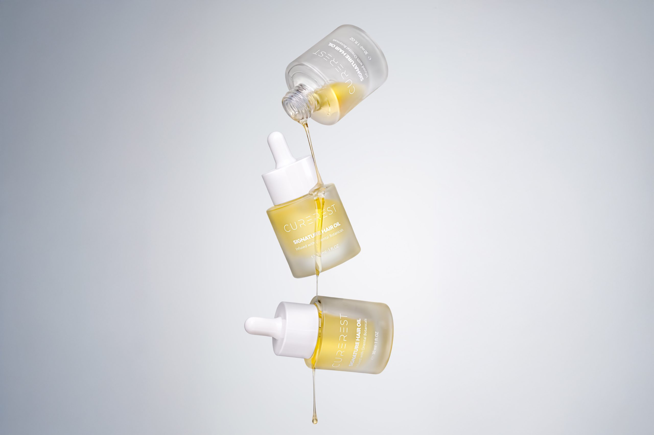 Curerest Hair Oil product shot with oil texture and droplets, campaign-ready imagery designed for ecommerce and advertising.