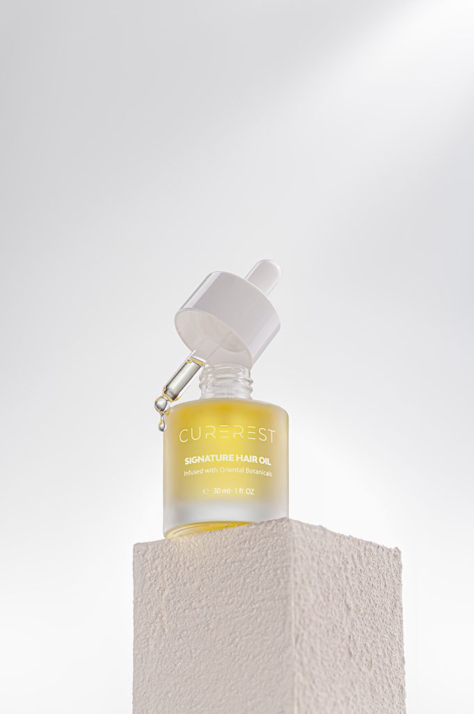 Curerest Hair Oil product shot with oil texture and droplets, campaign-ready imagery designed for ecommerce and advertising.