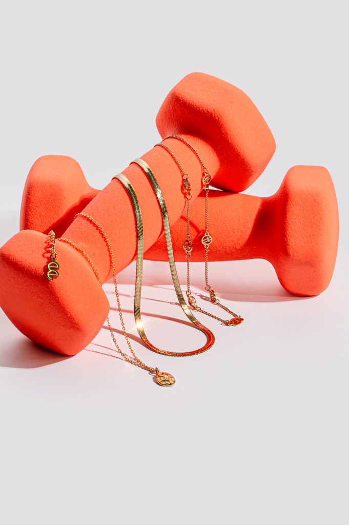 Gold jewellery necklaces photographed on a coral dumbbell prop in a studio product photography setup by Mindful Creatives in Adelaide.