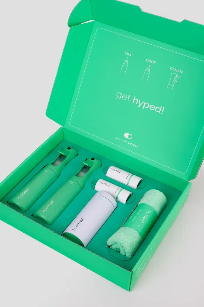 Open Hyprleaf starter kit box with two spray bottles, refill canister, refills, and cleaning towels