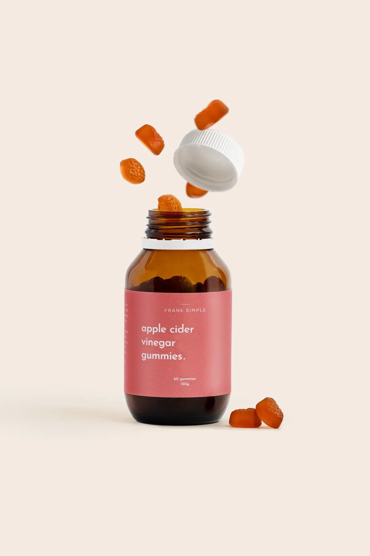 Frank Simple apple cider vinegar gummies bottle with gummies falling out on a cream background