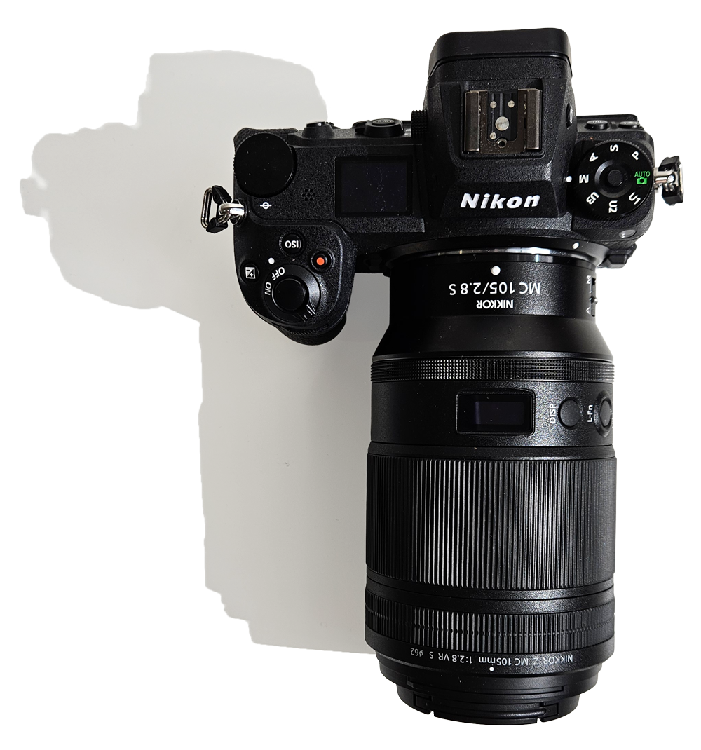 Nikon camera and macro lens casting a shadow across a white background.