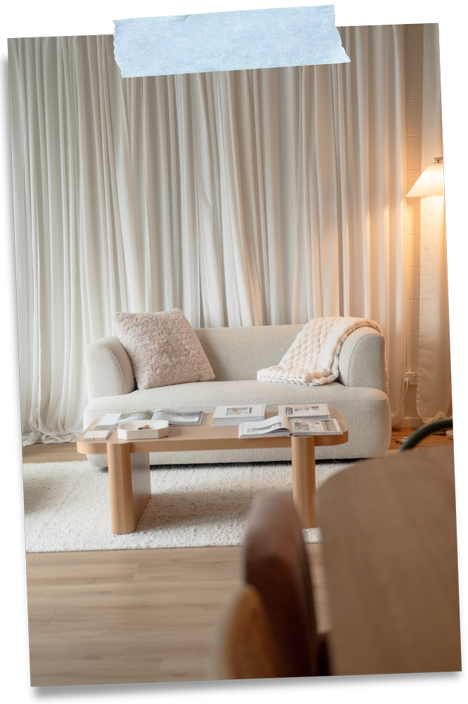 Interior of the Mindful Creatives Adelaide Hills studio with a cream sofa, curtains and coffee table.
