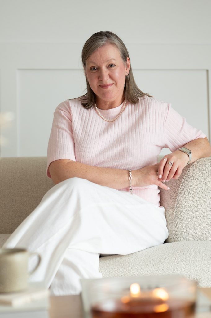 Woman wearing a pink top seated on a cream sofa during a Rapid Brand Session