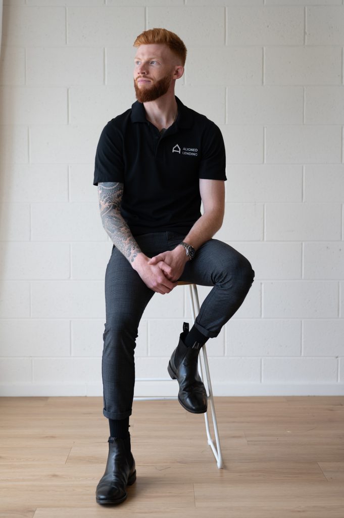 Man wearing an Aligned Lending polo seated on a stool during a Rapid Brand Session