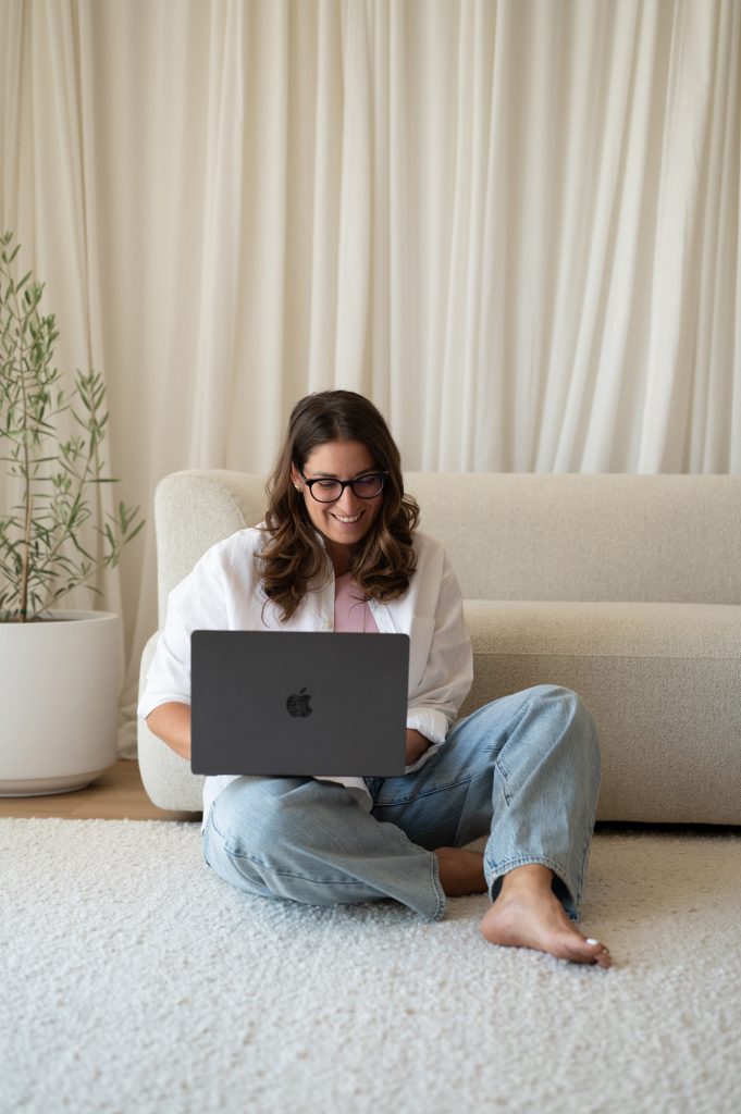 Woman sitting on the floor and working on a laptop during a Rapid Brand Session